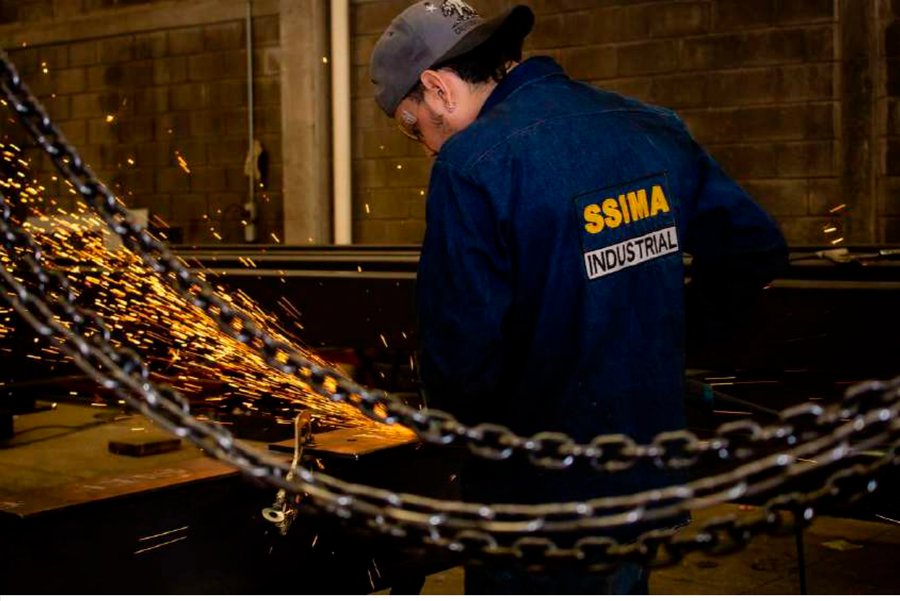 Soldador de SSIMA Industrial trabajando con esmeril, chispas de metal